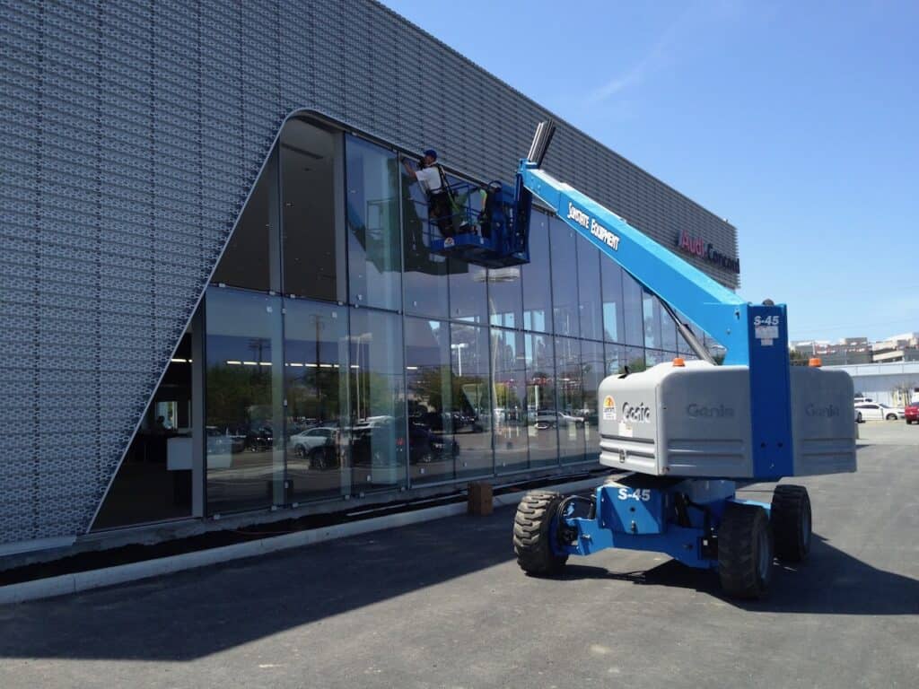 Boom lift positioned against a glass facade during installation