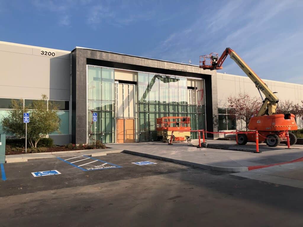 Boom lifts positioned for glazing work at a commercial building