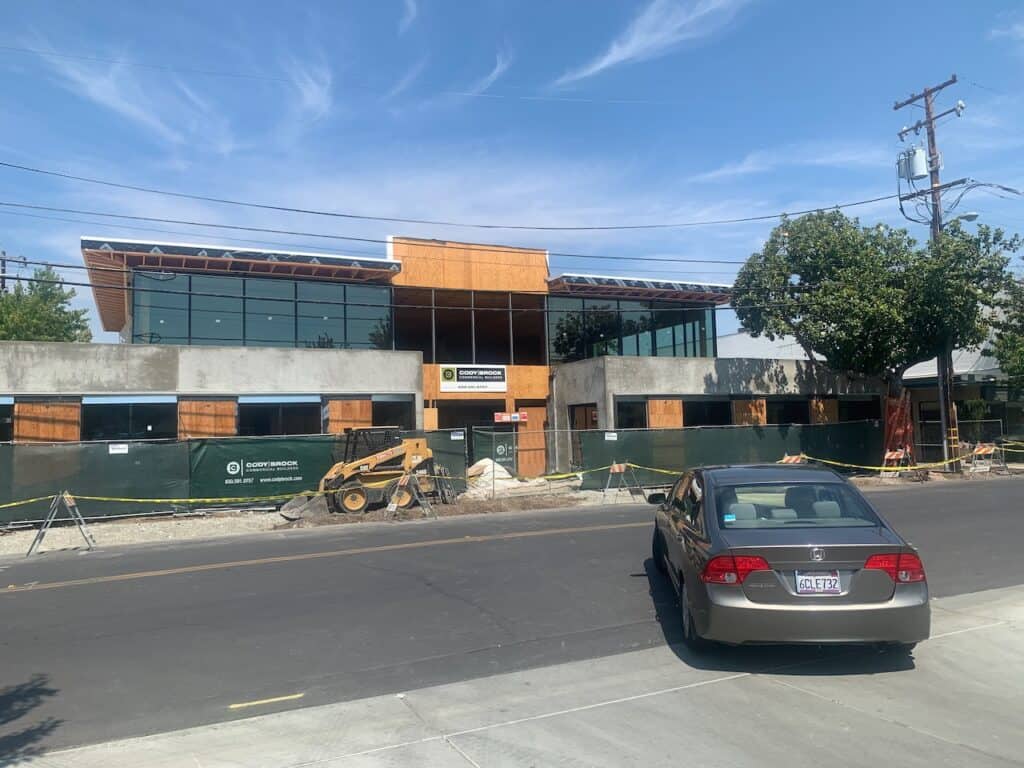 Commercial building exterior with storefront glazing and parking