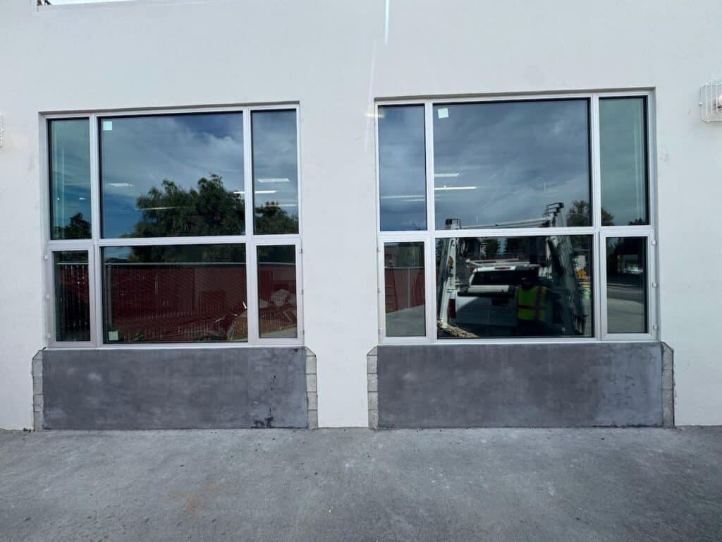 Pair of commercial storefront windows on a light grey building