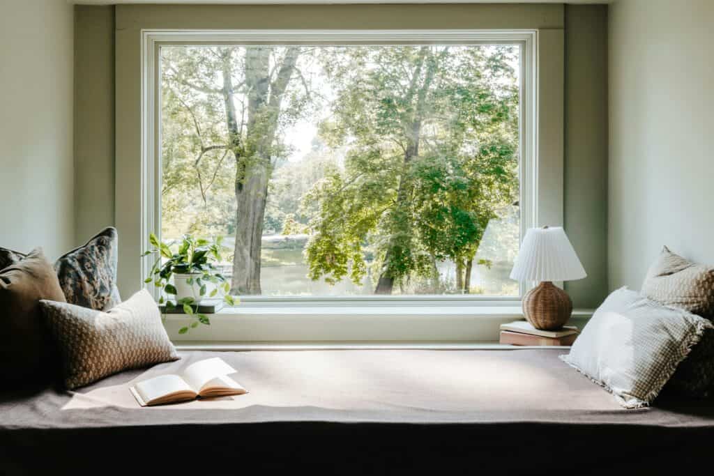 Cushioned window seat beneath a large picture window