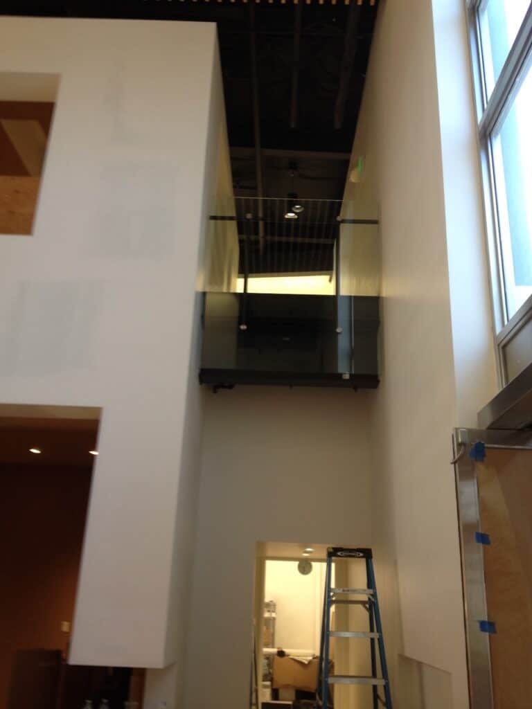 Dark framed glass railing along an upper floor
