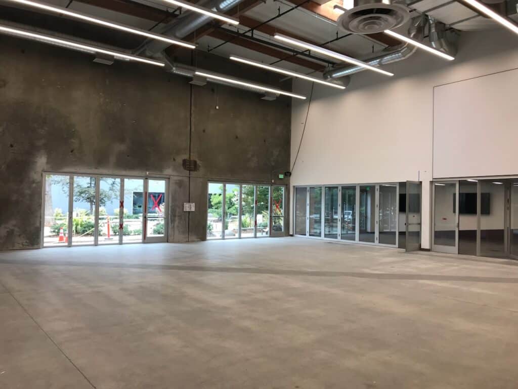 Empty commercial interior lit by full height windows