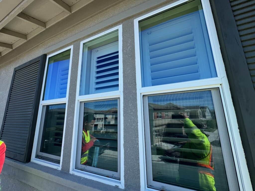 Newly installed energy efficient windows with the installation crew reflected