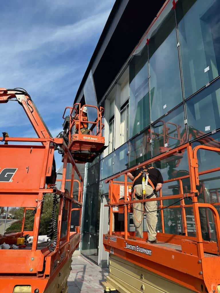 Glass panel lifted into place by boom lift