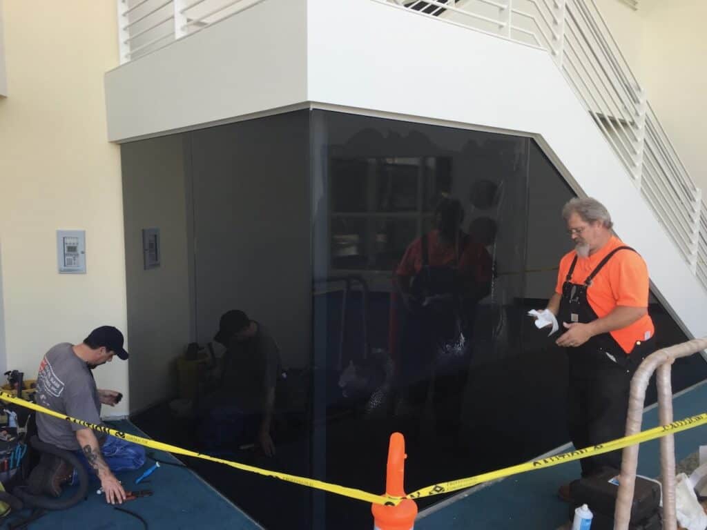 Glaziers installing glass panels on a building exterior
