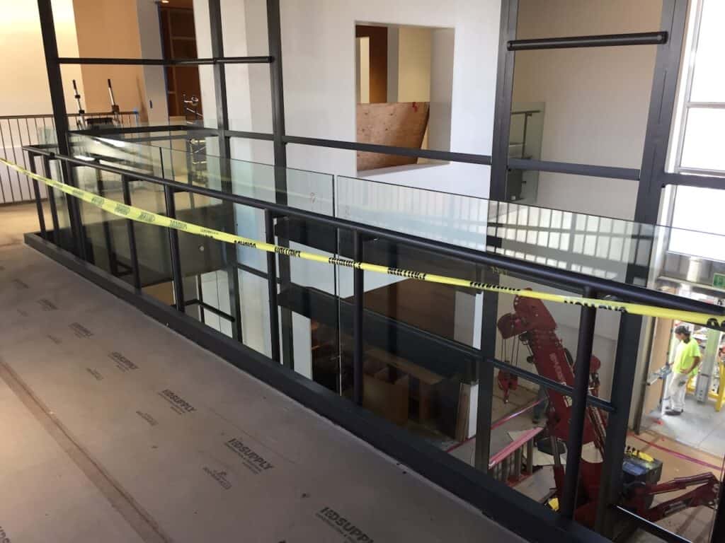 Interior walkway with a glass balustrade behind caution tape