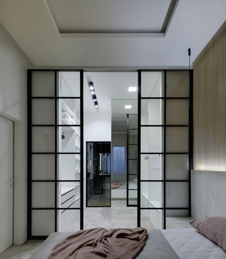 Kitchen separated by black framed glass partition doors