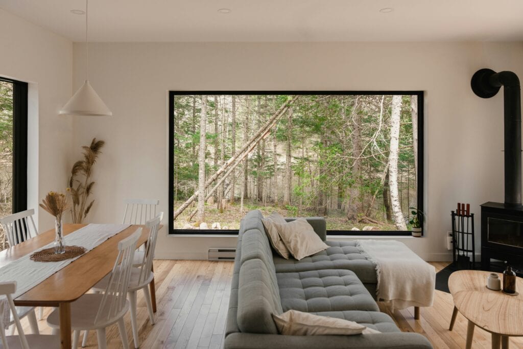 Living room with a large picture window overlooking woodland
