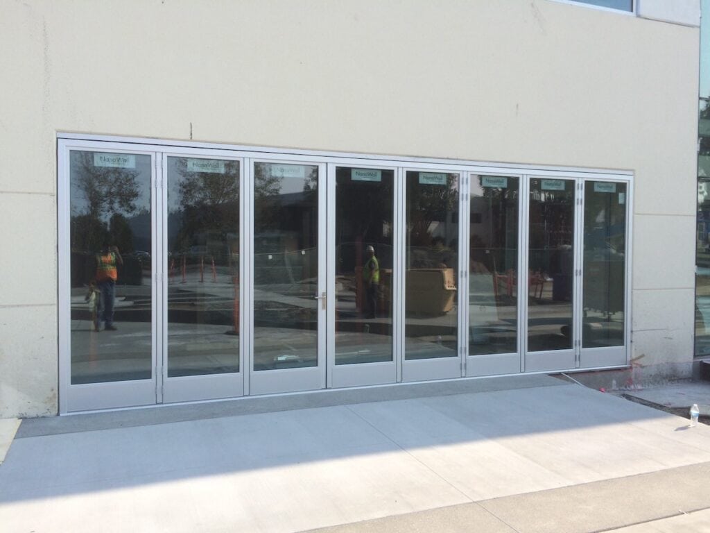 Long run of white framed glass doors and windows along a commercial frontage