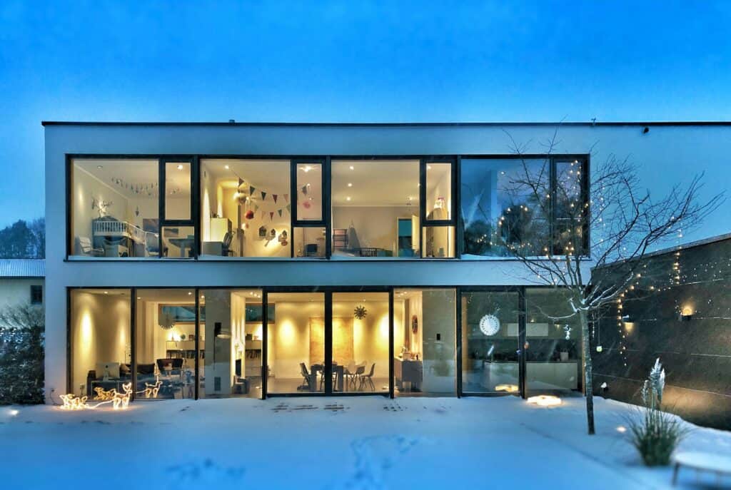 Modern home at night with a fully glazed frontage