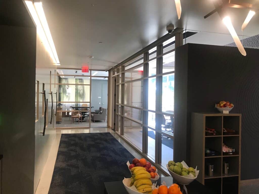 Office corridor lined with black framed glass partitions