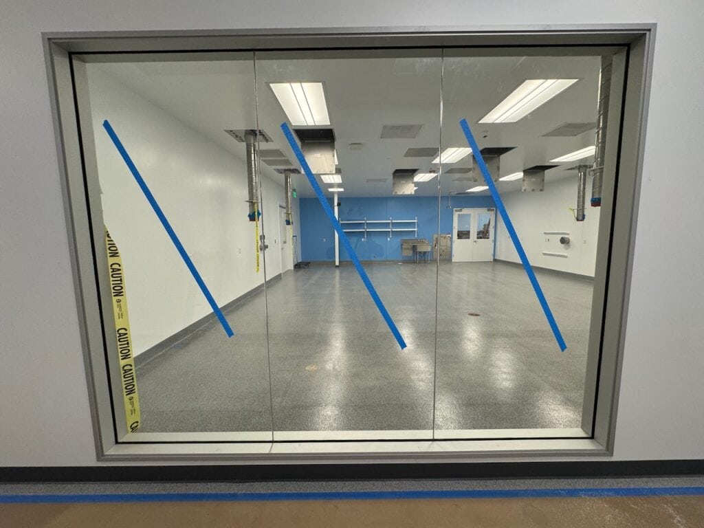 Interior office glass partition newly installed and marked with safety tape