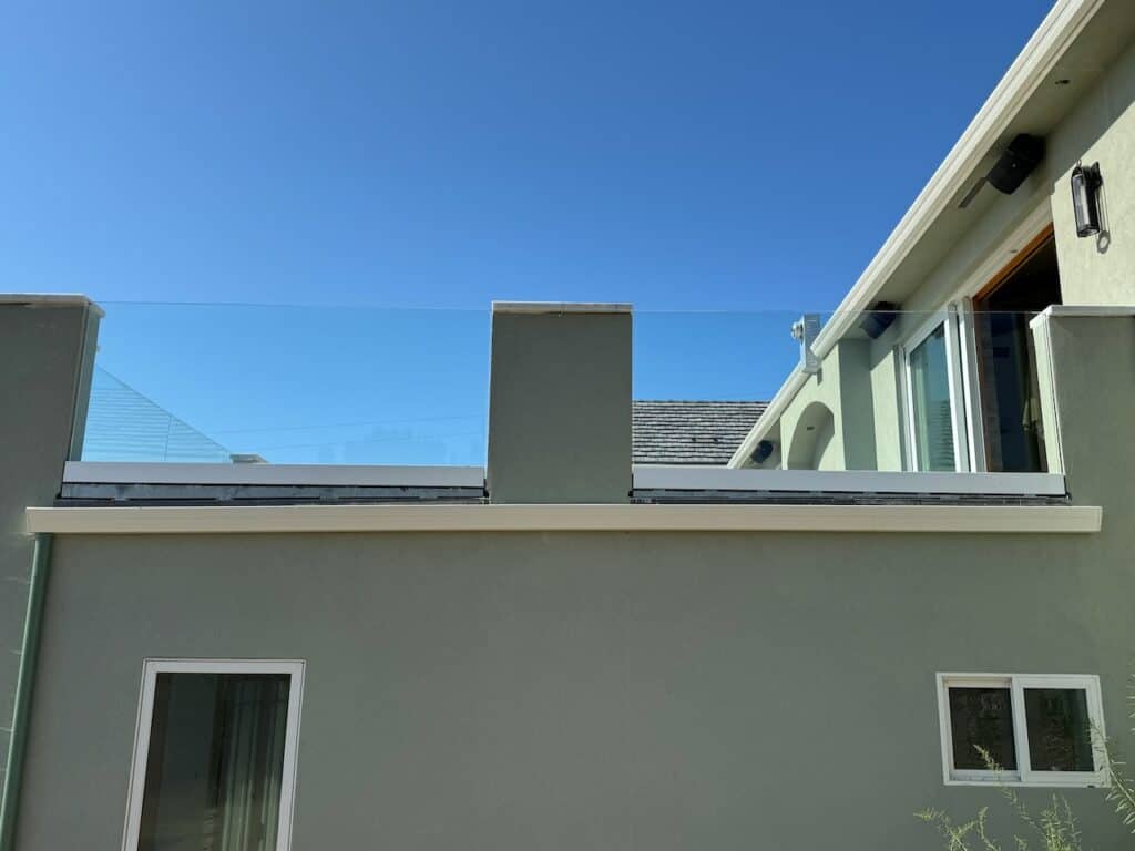 Rooftop glazing work on a commercial building under a clear sky