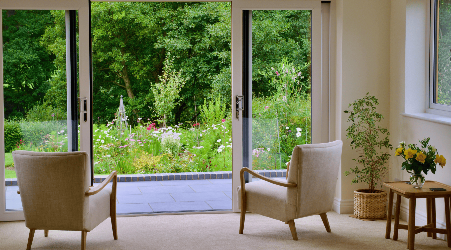 Sitting room with glass patio doors opening to a garden