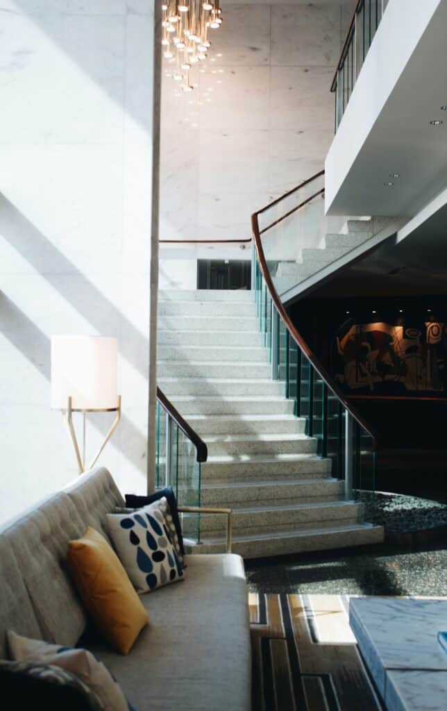 Staircase with a glass balustrade beside a floor lamp
