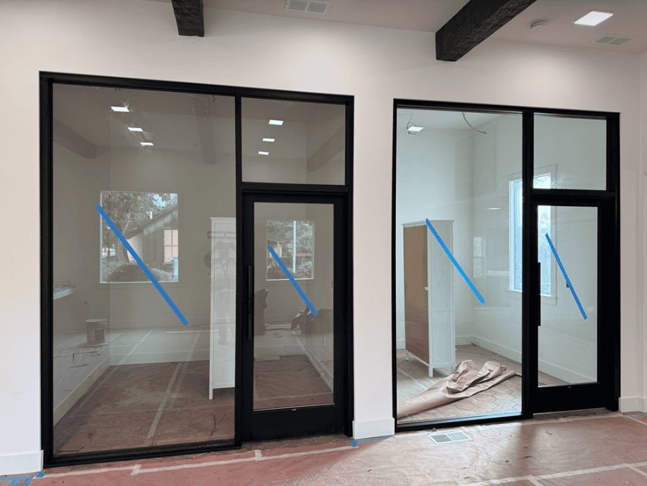 Storefront glass doors marked with safety tape after installation