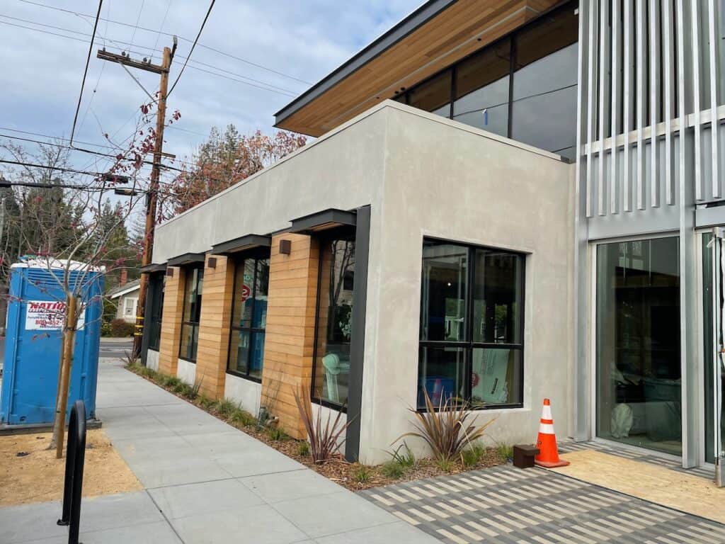 Street view of a commercial building with new storefront glazing