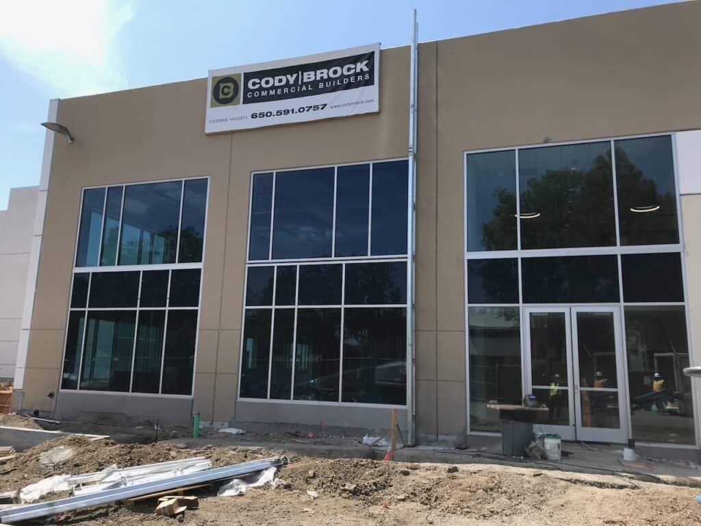 Two storey commercial office building with dark framed windows and a glass entrance