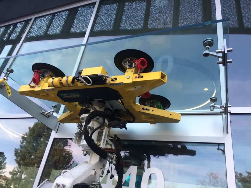 Vacuum lifting rig gripping a large glass panel during installation