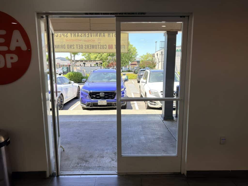 View out through storefront glazing toward the car park
