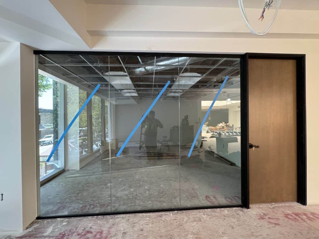 Wide interior glass partition enclosing a commercial space